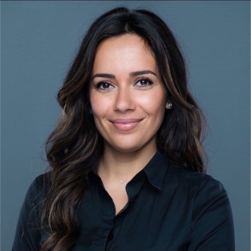 Portrait of a woman wearing a dark jacket over a dark top.